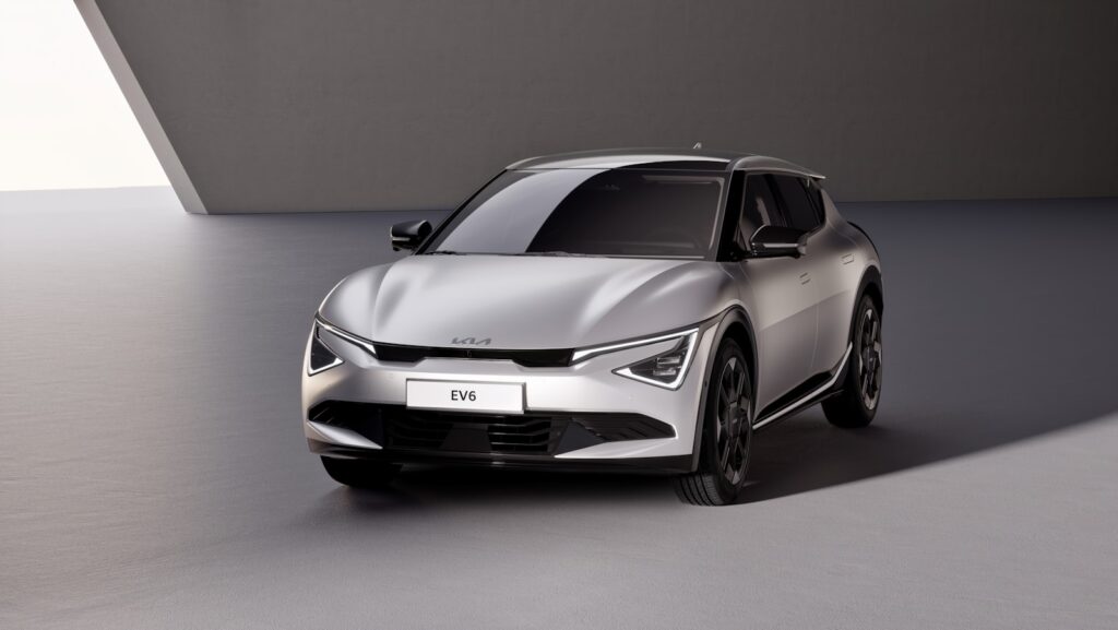 A silver car parked in a room next to a wall