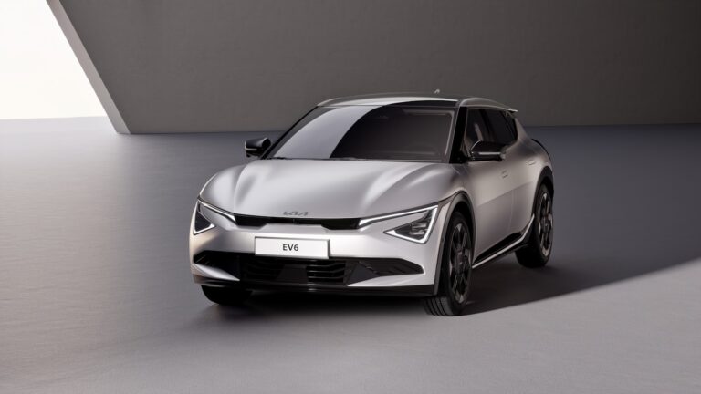 A silver car parked in a room next to a wall